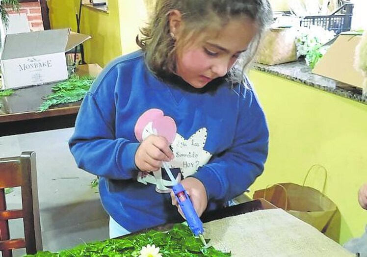 La pequeña Irene Suárez prepara su traje de flores del pantano